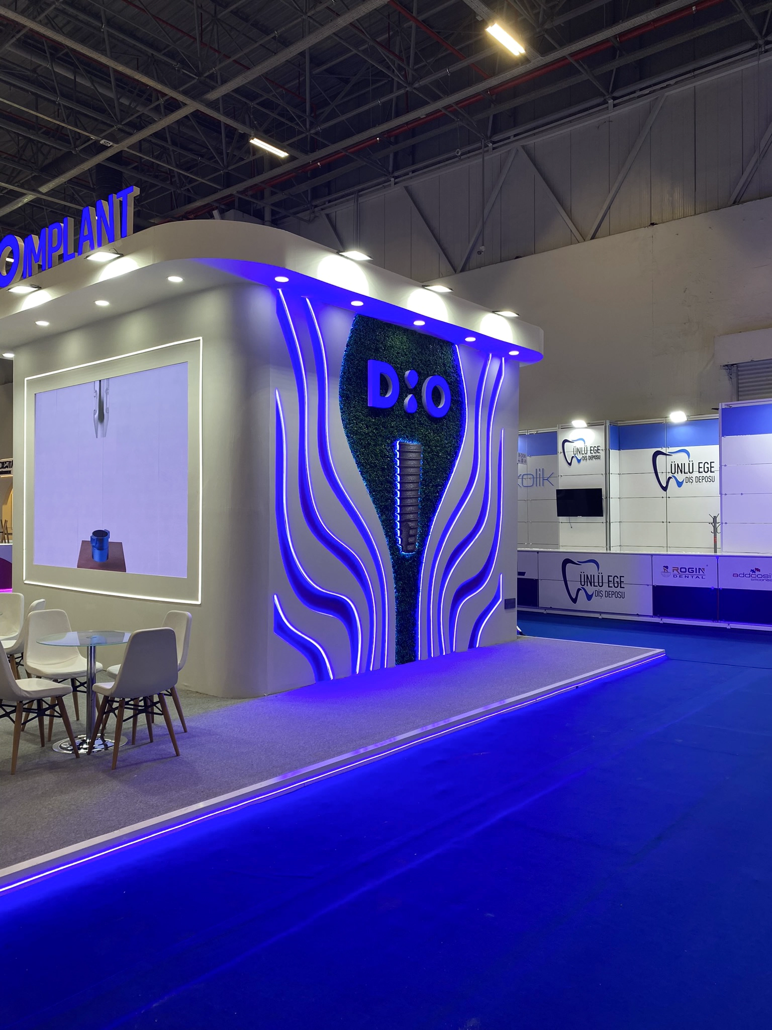 DIO Implant IDEX 2025 standı fotoğraf alanı ve ışıklı DIO logo cephesi